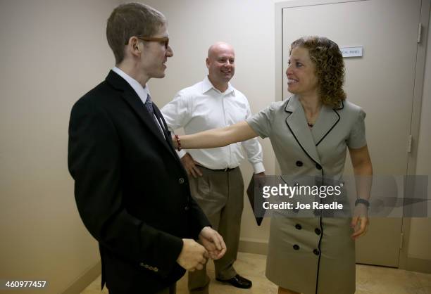 Rep. Debbie Wasserman Schultz speaks with Josh Benson as Martin West looks on during a press conference to speak about the Affordable Care Act during...