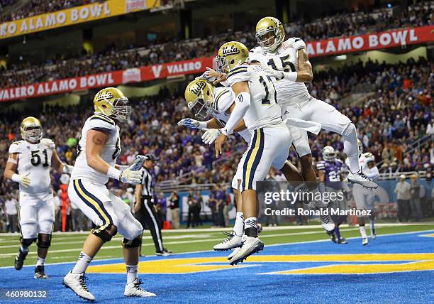 Brett Hundley of the UCLA Bruins celebrates his touchdown against the Kansas State Wildcats in the first quarter during the Valero Alamo Bowl at...