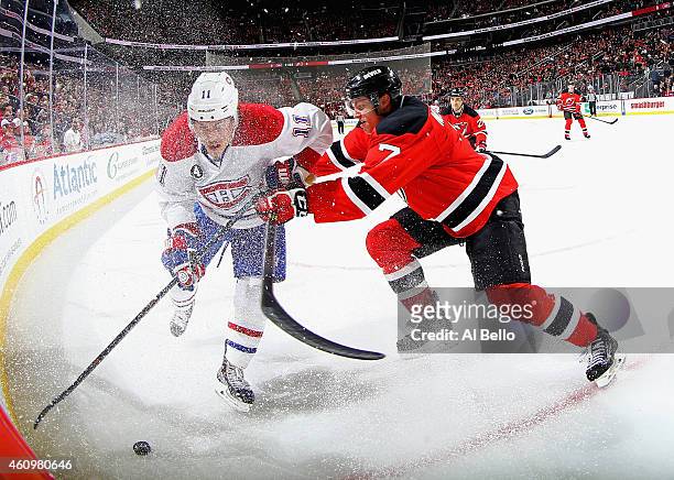 Jon Merrill of the New Jersey Devils checks Brendan Gallagher of the Montreal Canadiens during their game at the Prudential Center on January 2, 2015...