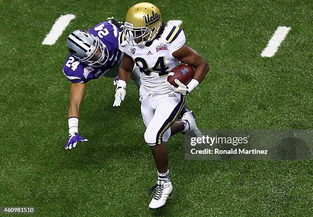 Paul Perkins of the UCLA Bruins runs for a touchdown past Nate Jackson of the Kansas State Wildcats in the second quarter during the Valero Alamo...