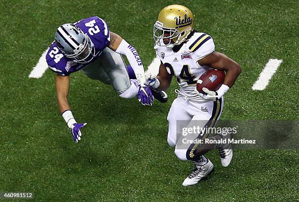 Paul Perkins of the UCLA Bruins runs for a touchdown past Nate Jackson of the Kansas State Wildcats in the second quarter during the Valero Alamo...