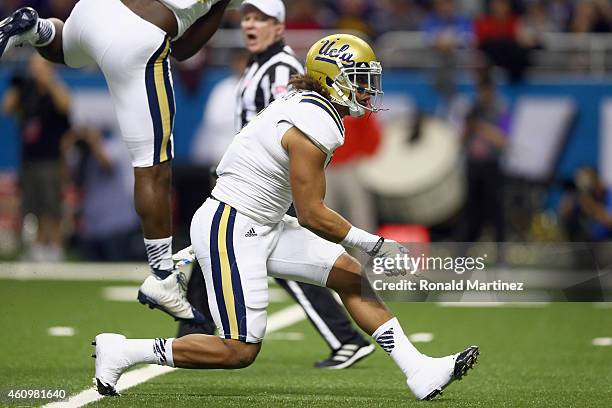 Eric Kendricks of the UCLA Bruins celebrates a quarterback sack against Jake Waters of the Kansas State Wildcats in the first quarter during the...