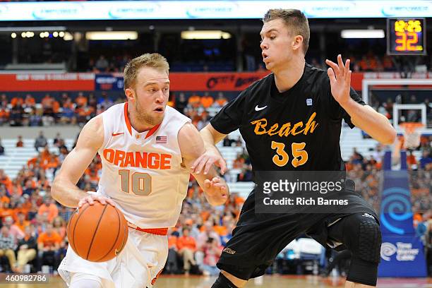 Trevor Cooney of the Syracuse Orange drives to the basket against the defense of Jack Williams of the Long Beach State 49ers during the first half at...