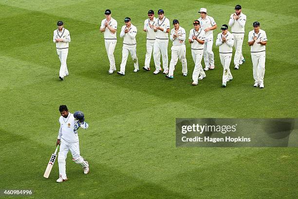 Kumar Sangakkara of Sri Lanka is applauded by New Zealand players as he leaves the field at the end of play after surpassing 12,000 test runs during...