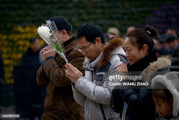People pray for victims at the site of the New Year's Eve stampede in Shanghai on January 3, 2015. The New Year's stampede just before midnight on...