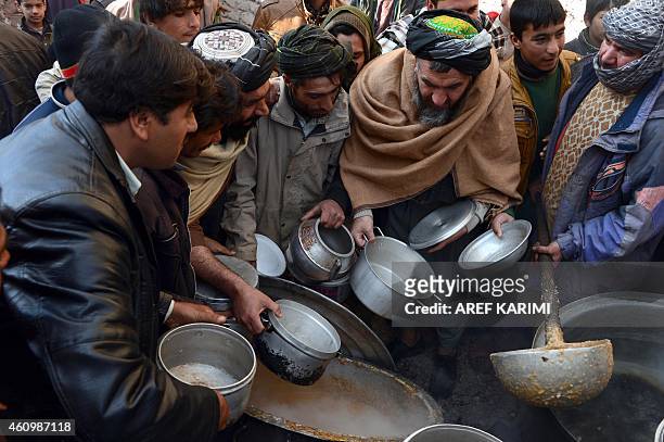 Afghan men receive food donated by a private charity during a food distribution on the occasion of Eid-e-Milad-un-Nabi, the festival of the birth of...
