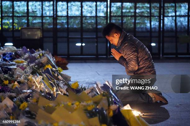 Man prays for people killed in a New Year's Eve crush at the site of the stampede in Shanghai on January 3, 2015. Dozens of deaths from a crush in...