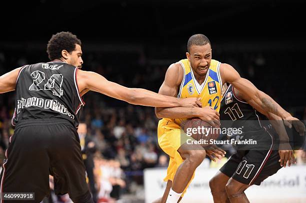 Dru Joyce of Braunschweig is challenged by Lawrence Hill and David Holston of Artland during the Bundesliga basketball game between Basketball Loewen...