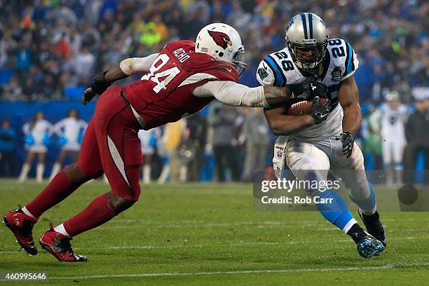 Jonathan Stewart of the Carolina Panthers breaks a tackle from Sam Acho of the Arizona Cardinals during their NFC Wild Card Playoff game at Bank of...