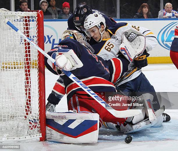 Henrik Lundqvist of the New York Rangers looks behind him after making a save as Brian Flynn of the Buffalo Sabres crashes the net looking for a...