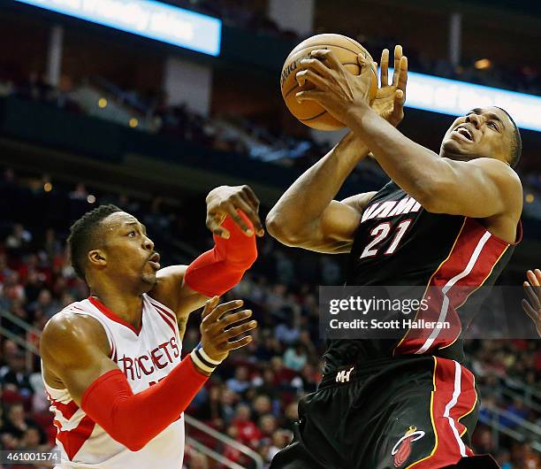 Dwight Howard of the Houston Rockets battles for a loose basketball with Hassan Whiteside of the Miami Heat during their game at the Toyota Center on...