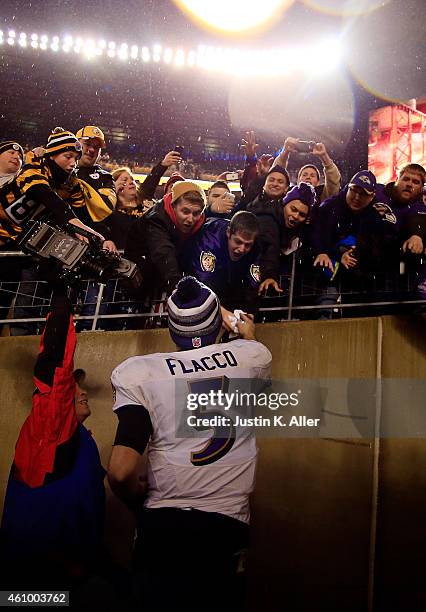 Joe Flacco of the Baltimore Ravens celebrates with fans after defeating the Pittsburgh Steelers 30-17 in their AFC Wild Card game at Heinz Field on...