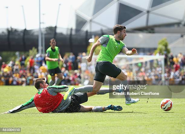 Tom Oar of Australia avoids a tackle from Terry Antonis during an Australian Socceroos training session at Collingwood training Ground on January 4,...