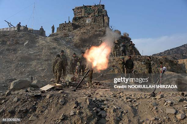 In this picture taken on January 3 Afghan National Army soldiers fire a 120mm mortar round during an ongoing anti-Taliban operation in Dangam...