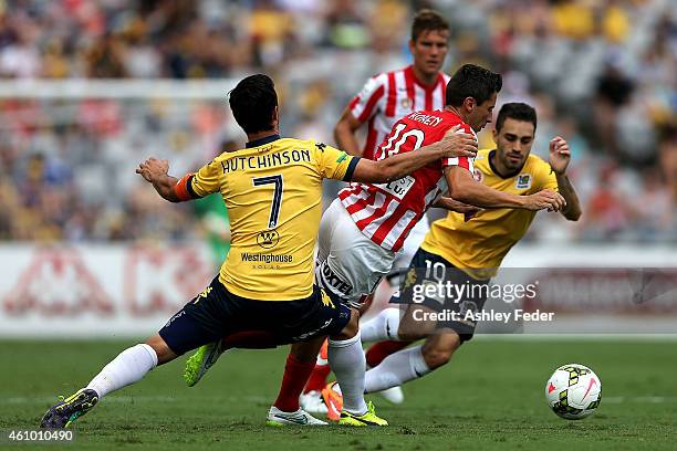 Robert Koren of Melbourne City falls to the ground with John Hutchinson and Anthony Caceres of the Mariners contesting the ball during the round 15...