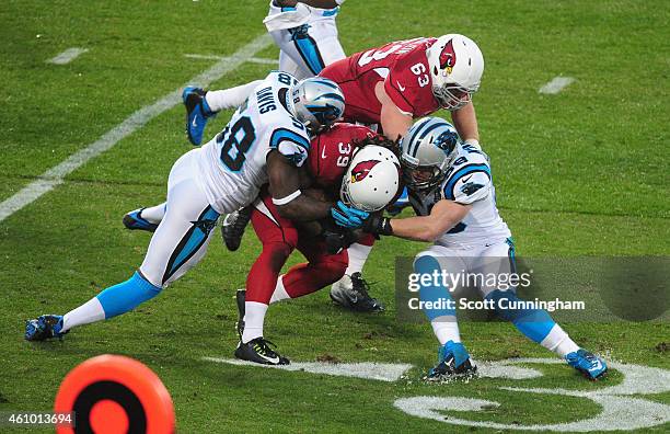 Thomas Davis and Luke Kuechly of the Carolina Panthers tackle Robert Hughes of the Arizona Cardinals during the NFC Wild Card Playoff game on January...