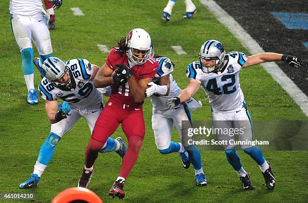 Larry Fitzgerald of the Arizona Cardinals runs with a catch against Luke Kuechly, Tre Boston, and Colin Jones of the Carolina Panthers during the NFC...