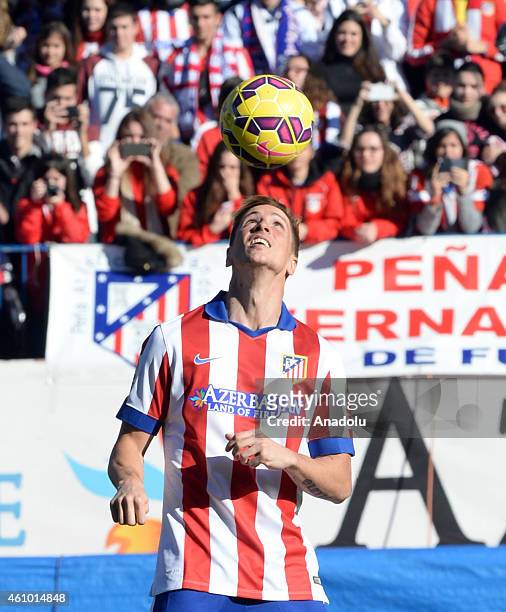 Atletico Madrid's new signing Spanish forward Fernando Torres plays with ball during his official presentation at the Vicente Calderon stadium in...