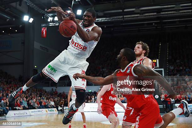 Trevor Mbakwe of Brose Baskets is challenged by Bo McCalebb and John Bryant of Muenchen during the Beko BBL basketball match between Brose Baskets...