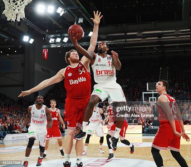 Bradley Wanamaker of Brose Baskets scores against John Bryant of Muenchen during the Beko BBL basketball match between Brose Baskets and FC Bayern...