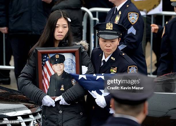 Pei Xia Chen , widow of New York Police Officer Wenjian Liu , walks with his portrait during the funeral for Officer Wenjian Liu in the Dyker Heights...