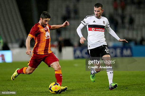 Oguzhan Ozyakup of Besiktas is in action against Sabri Sarioglu of Galatasaray during the Turkish Spor Toto Super League soccer match between...