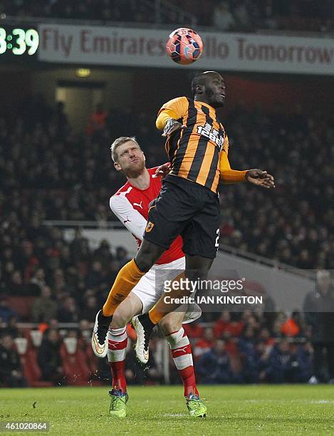 Arsenals German defender Per Mertesacker vies with Hull Citys Ivorian striker Yannick Sagbo during the English FA Cup third round football match...