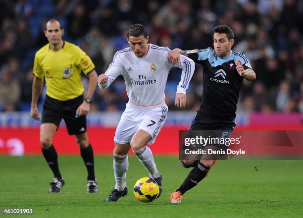 Cristiano Ronaldo of Real Madrid CF battles for the ball against Hugo Mallo of RC Celta de Vigo while referee Alfonso Alvarez looks on during the La...