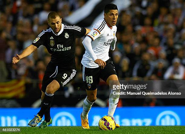 Enzo Perez of Valencia competes for the ball with Karim Benzema of Real Madrid during the La Liga match between Valencia CF and Real Madrid CF at...