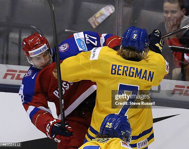 Vyacheslav Leshenko and Julius Bergman collide as Team Russia plays Team Sweden in the semi final round of the IIHF World Junior Hockey Tournament at...