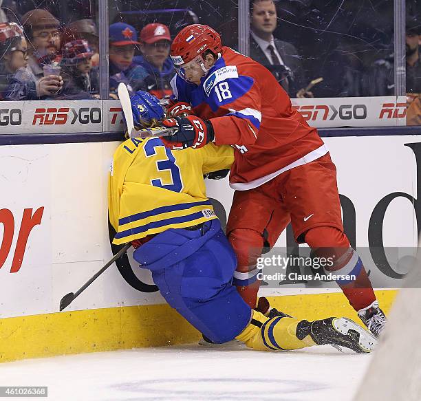 Maxim Mamin of Team Russia takes a penalty by slamming William Lagesson of Team Sweden into the boards during a semi-final game in the IIHF World...