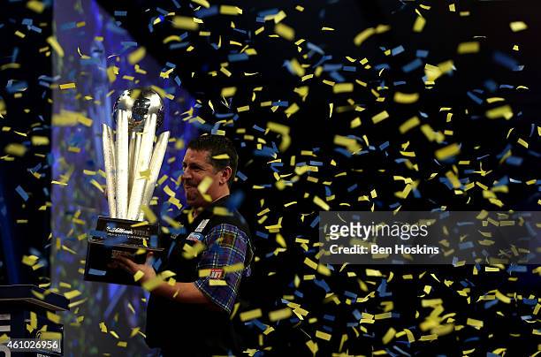 Gary Anderson of Scotland celebrates with the Sid Waddell trophy after defeating Phil Taylor of England in the final of the 2015 William Hill PDC...