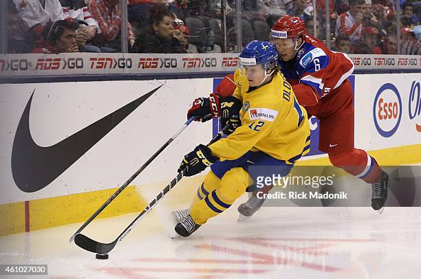 Sweden's Victor Olofsson keeps Russian player Vladislav Gavrikov off the puck. 2015 IIHF World Junior Championship hockey, 3rd period Semi Final...