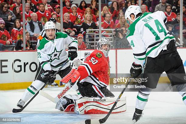 Jamie Benn of the Dallas Stars hits the puck to score on goalie Corey Crawford of the Chicago Blackhawks as Colton Sceviour watches from behind...