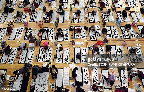 Contestants write letters during the 51st annual new year Calligraphy contest at the Budokan hall in Tokyo on January 5, 2015. About 3,150 people...