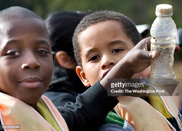 Haynes Public Charter students Delante Vaughn and Abdulrahim Robinson show off some trash they picked up while on a canoe trip on the Anacostia River...