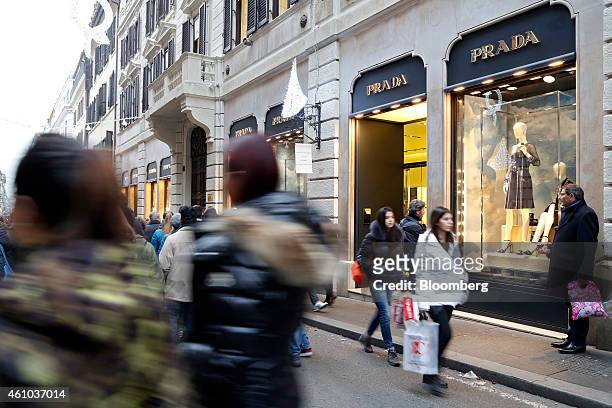 Pedestrians carry shopping bags as they walk past a Prada SpA luxury store on Via Condotti street on the first day of the New Year sales in Rome,...