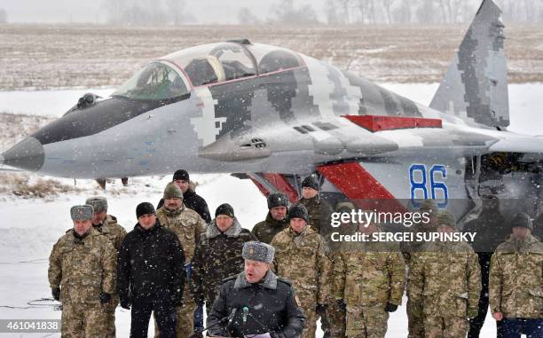 Ukrainian servicemen listen on as Ukrainian President Petro Poroshenko gives a speech as he hands over new military equipment to the Ukrainian forces...