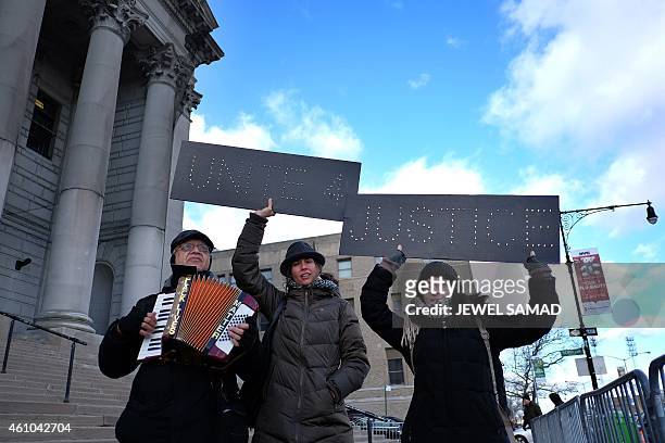 Protesters hold up signs during a demonstration outside the courthouse in New York's borough of Staten Island on January 5 before a hearing in a...