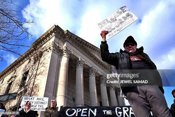 Protesters display a banner and placards during a demonstration outside the courthouse in New York's borough of Staten Island on January 5 before a...