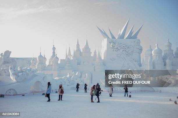 Visitors look at snow sculptures during the 16th Harbin International Ice and Snow Festival in Harbin, northeast China's Heilongjiang province on...