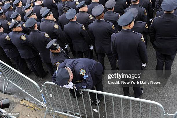 Sergeant form the 84 Pct. Is over come with emotion as the casket with the remains of NYPD officer Wenjian Liu leave the Aievoli Funeral Home in...