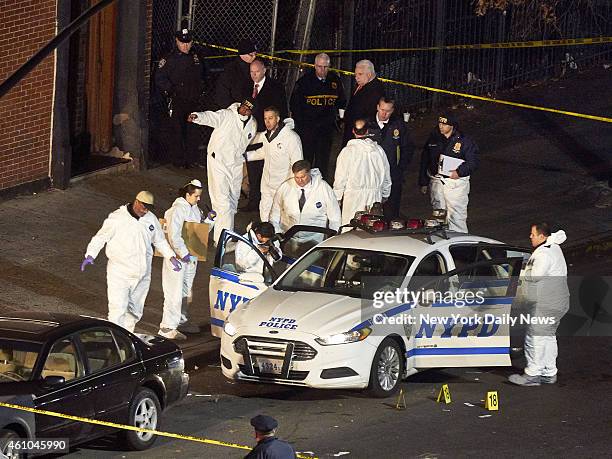 Crime scene technicians examine the squad car in which New York Police Department officers Rafael Ramos and Wenjian Liu were shot and killed in by...