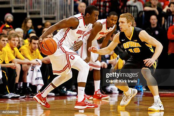 Mike Gesell of the Iowa Hawkeyes guards Shannon Scott of the Ohio State Buckeyes during the game at Value City Arena on December 30, 2014 in...