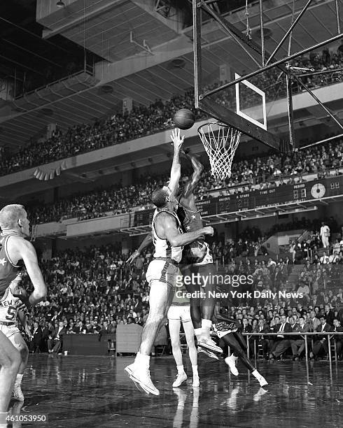 Basketball College All Stars vs N.Y. Knicks All Star Oscar Robertson manages layup despite late lunge by Knicks' Charlie Tyra during first half of...