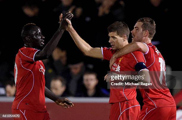 Steven Gerrard of Liverpool is congratulated by teammates Mamadou Sakho and Jordan Henderson after scoring his team's second goal from a free kick...