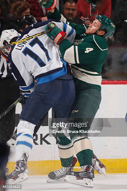 Stu Bickel of the Minnesota Wild and Adam Lowry of the Winnipeg Jets battle for the puck during the game on December 27, 2014 at the Xcel Energy...