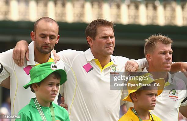 Nathan Lyon , Ryan Harris and David Warner of Australia react during the national anthem during day one of the Fourth Test match between Australia...