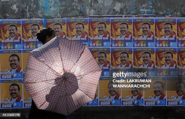 Sri Lankan woman walks past election posters of President Mahinda Rajapaksa in the Colombo suburb of Piliyandala on January 6, 2015. Rajapaksa will...