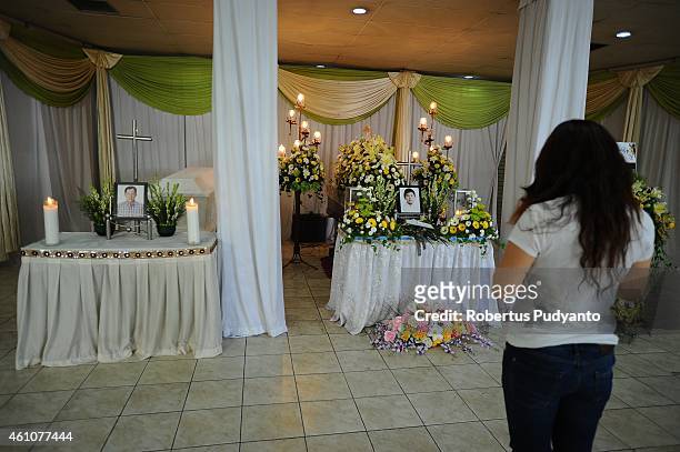 Relatives of Grayson Herbert Linaksita and Tony Linaksita, victims of the AirAsia flight QZ8501 disaster, pray at Adi Yasa funeral house on January...